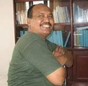 Foto Pak Bram sedang berpose di ruangannya