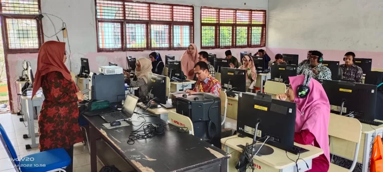 Peserta yang sedang berhadapan dengan komputer mendengarkan pemateri dengan serius