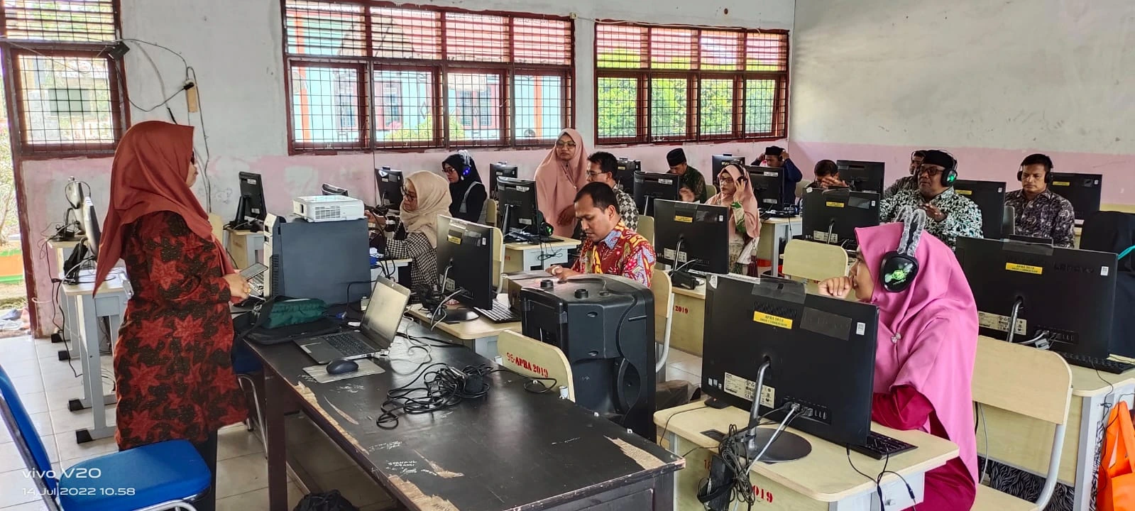 Peserta yang sedang berhadapan dengan komputer mendengarkan pemateri dengan serius